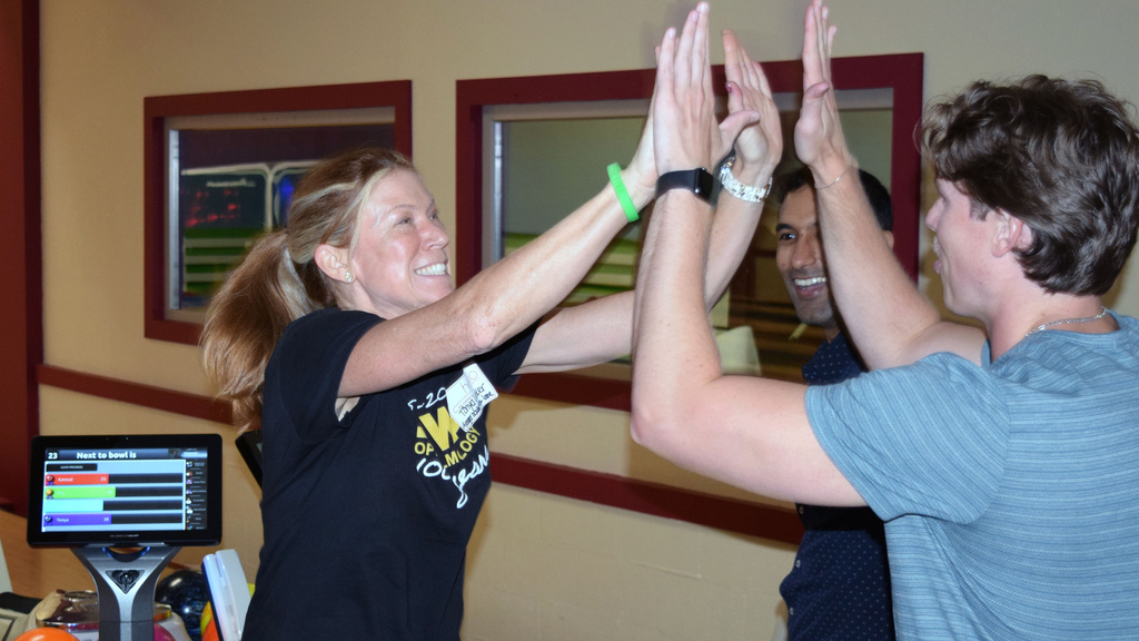 Tonya Looker gives a high five to Kanwal Matharu and Alec Marticoff